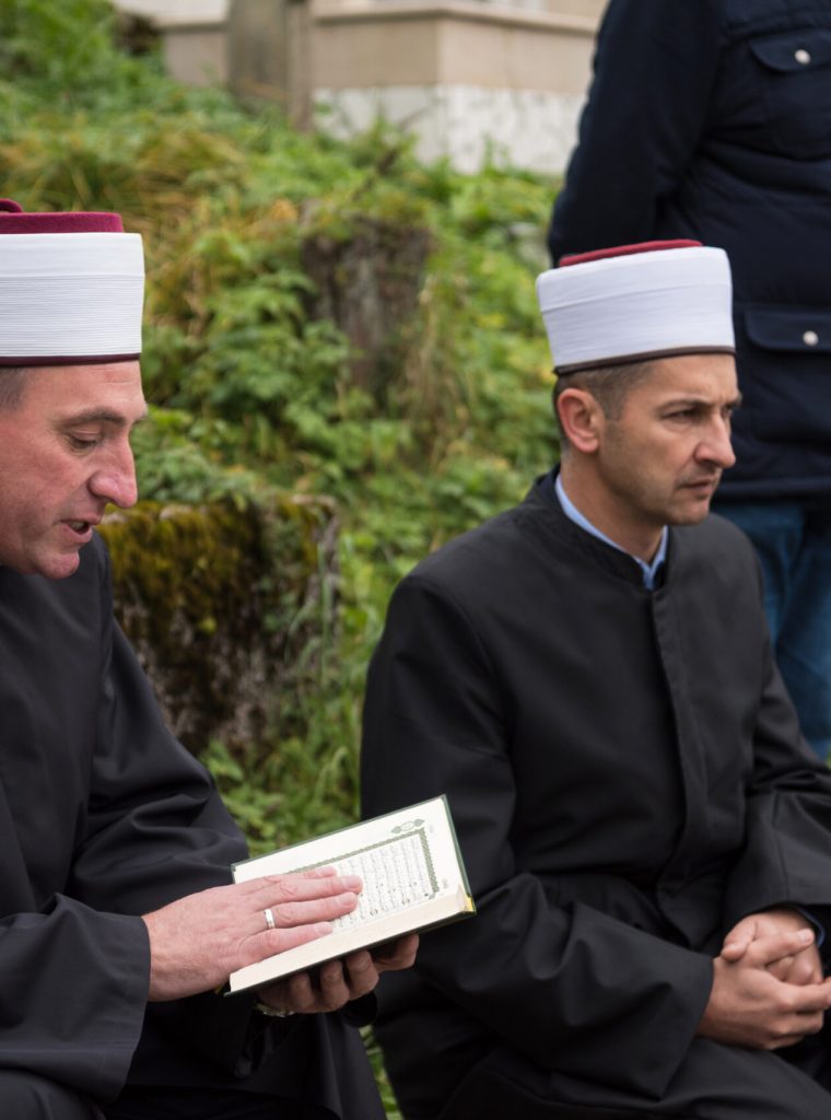 quran holy book reading by imam  on islamic funeral with white thumb stones graweyard background